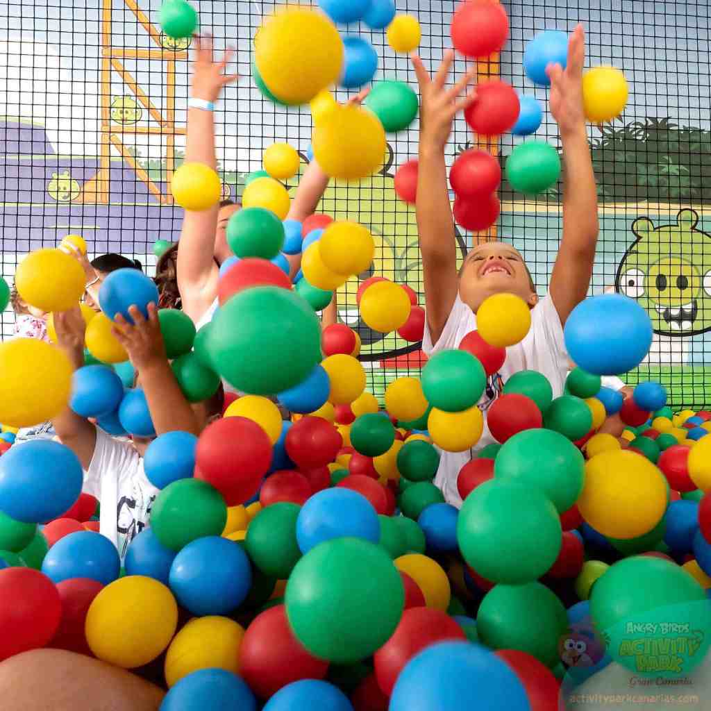 Children playing joyfully in a colorful ball pit.