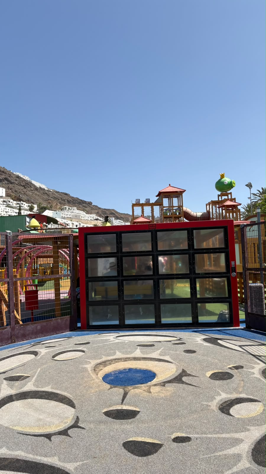 Colorful playground with climbing structures under clear blue sky.