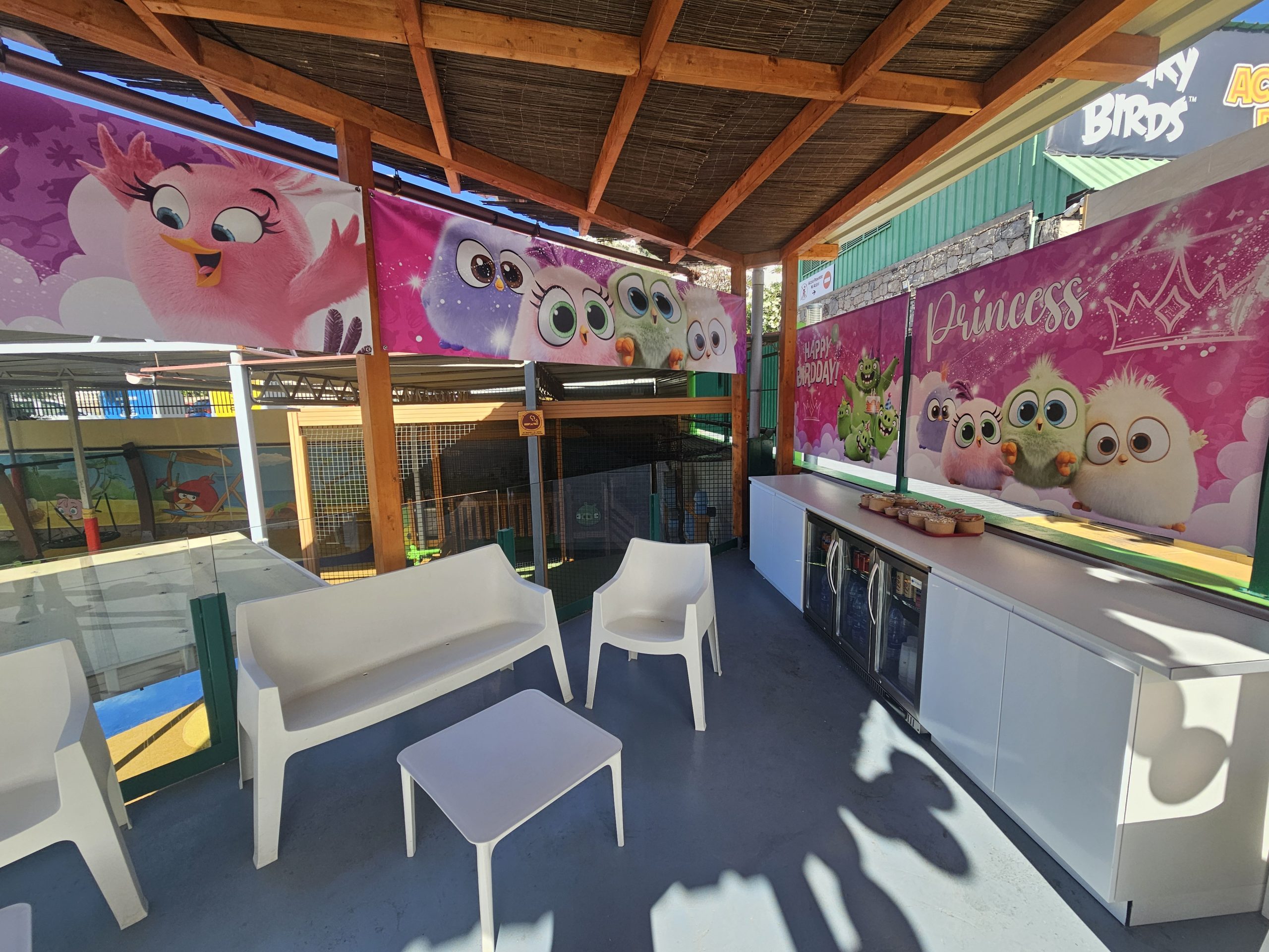 Outdoor seating area with child-themed banners and white furniture.