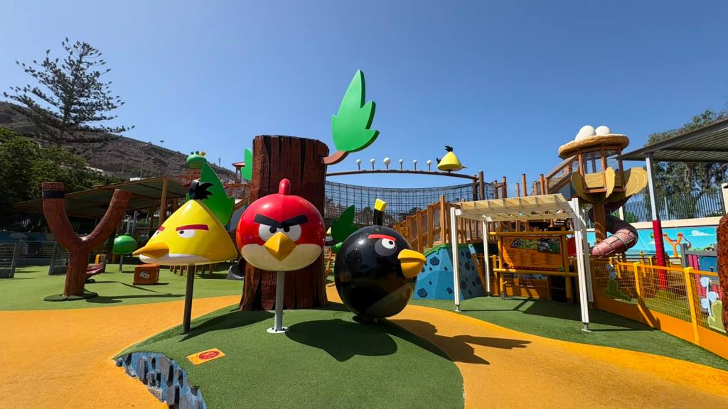 Playground with large Angry Birds figures and climbing structures under a clear blue sky.