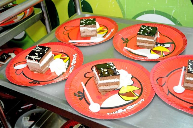 Chocolate cake slices on Angry Birds plates with whipped cream.