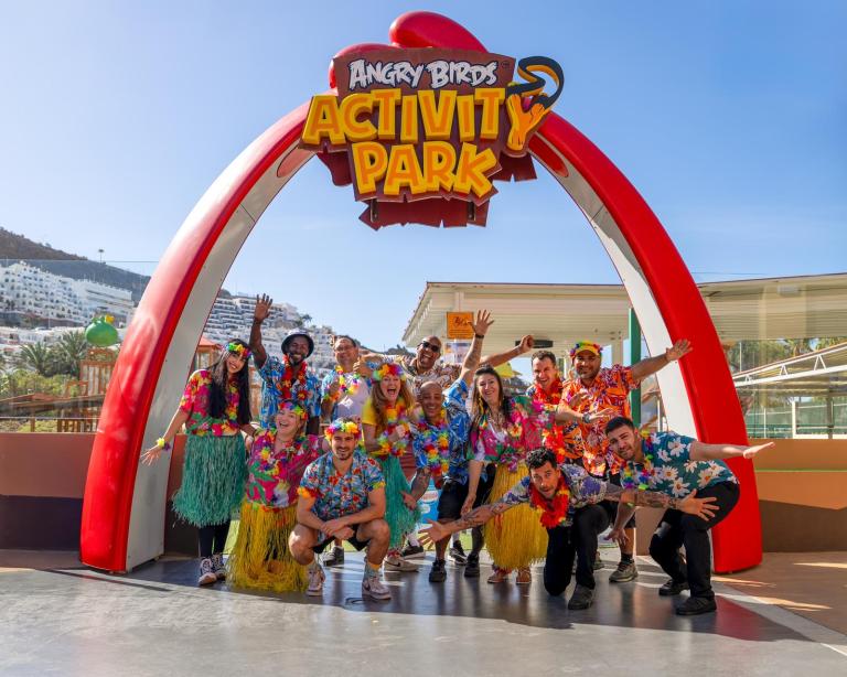 Group in colorful attire posing at Angry Birds Activity Park entrance.